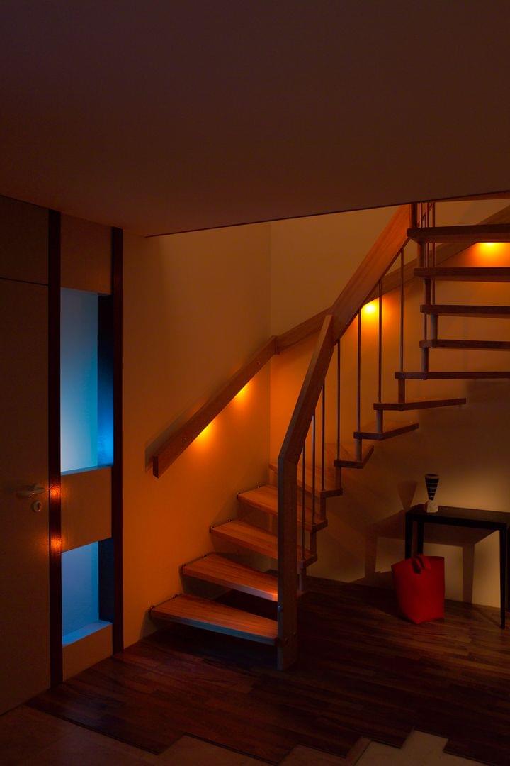 Holztreppe mit Treppenlicht im Wandhandlauf