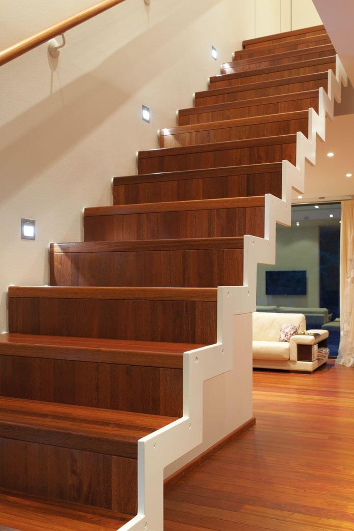 Stahltreppe Ferro mit Holzstufen gerade Stahlwangentreppe mit Setzstufen weiss lackierter Wange und Holz Wandhandlauf Treppenlicht